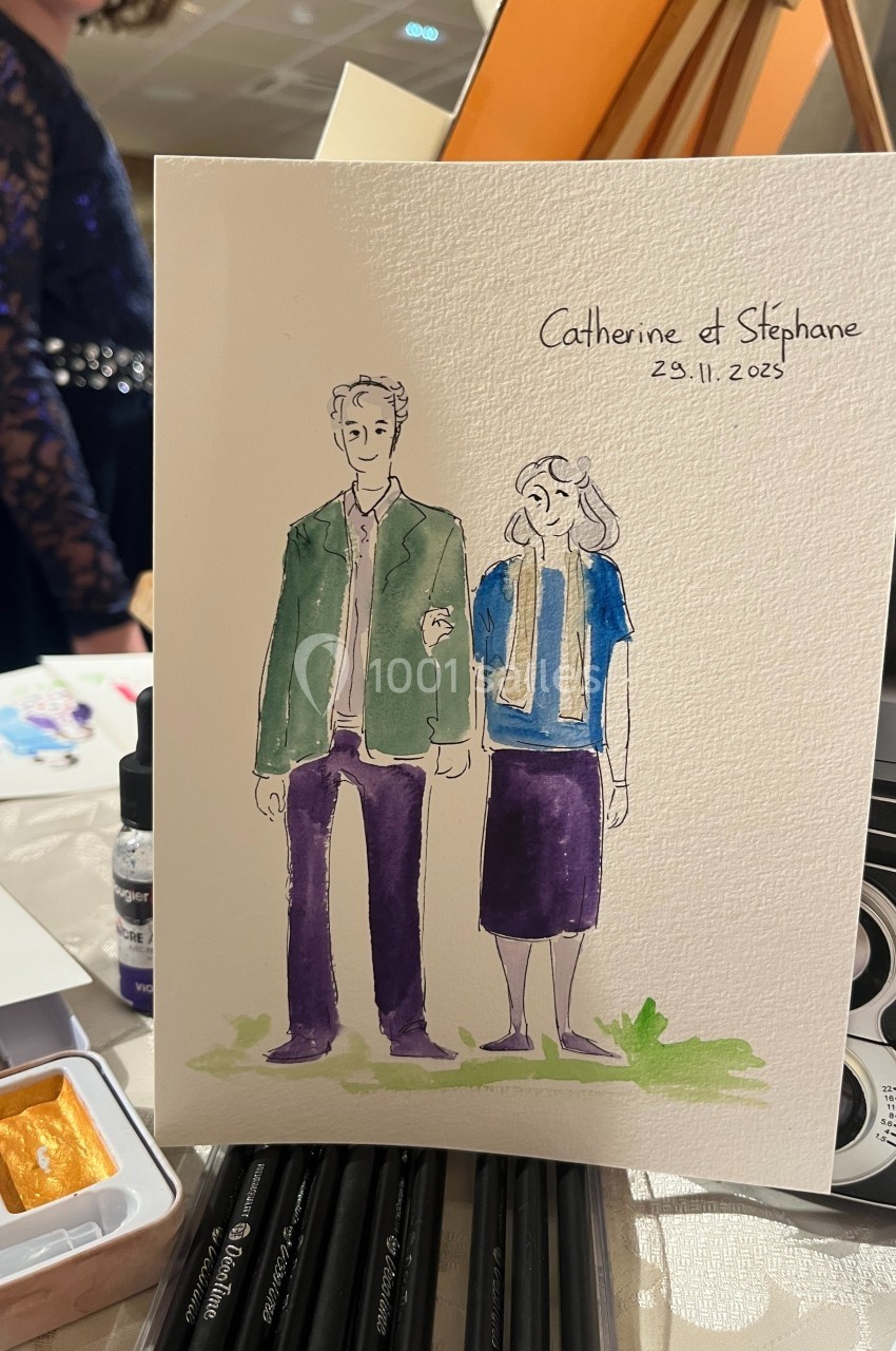 Illustration d'un couple dessiné à l'aquarelle sur une carte, posée sur une table avec des fournitures d'art.