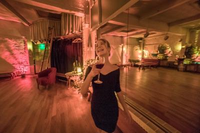 Salle spacieuse avec éclairage tamisé orange, murs en pierre, bancs en bois et décorations végétales.