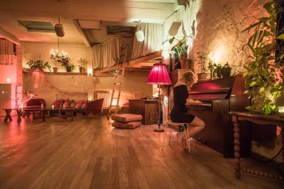 Salle spacieuse avec éclairage tamisé orange, murs en pierre, bancs en bois et décorations végétales.