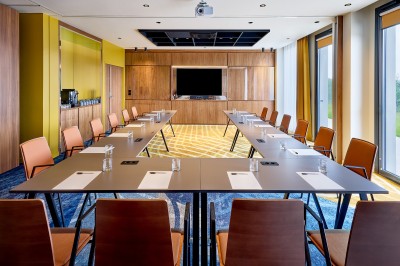 Salle de bain moderne avec baignoire, paroi vitrée, lavabo avec miroir éclairé et étagère contenant des serviettes.