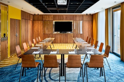 Salle de bain moderne avec baignoire, paroi vitrée, lavabo avec miroir éclairé et étagère contenant des serviettes.