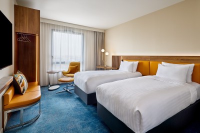Salle de bain moderne avec baignoire, paroi vitrée, lavabo avec miroir éclairé et étagère contenant des serviettes.