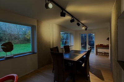 Vue d'un intérieur avec un espace ouvert, un bar en briques, un parquet clair et une mezzanine avec rambarde blanche.