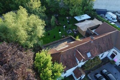 Vue d'un intérieur avec un espace ouvert, un bar en briques, un parquet clair et une mezzanine avec rambarde blanche.