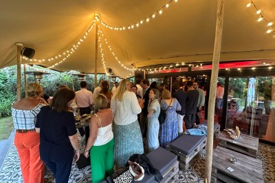 Camion de restauration éclairé la nuit, stationné devant un bâtiment illuminé par une lumière bleue.