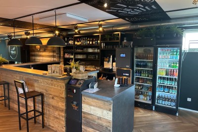 Camion de restauration éclairé la nuit, stationné devant un bâtiment illuminé par une lumière bleue.