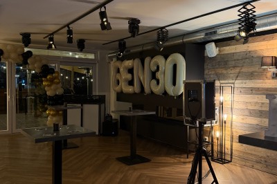 Camion de restauration éclairé la nuit, stationné devant un bâtiment illuminé par une lumière bleue.