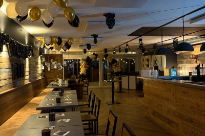 Camion de restauration éclairé la nuit, stationné devant un bâtiment illuminé par une lumière bleue.
