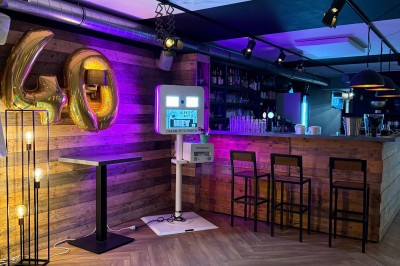 Camion de restauration éclairé la nuit, stationné devant un bâtiment illuminé par une lumière bleue.