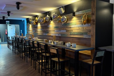 Camion de restauration éclairé la nuit, stationné devant un bâtiment illuminé par une lumière bleue.