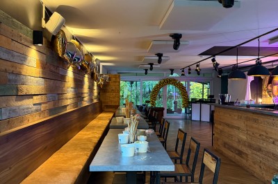 Camion de restauration éclairé la nuit, stationné devant un bâtiment illuminé par une lumière bleue.