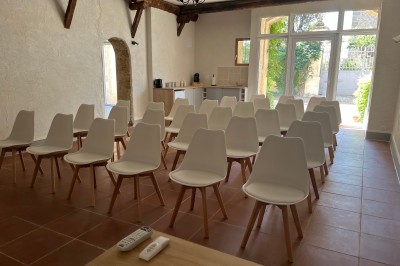 Porte-fenêtre vitrée blanche encadrée de pierre, avec une plante grimpante et une jardinière en pierre à droite.