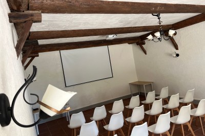 Porte-fenêtre vitrée blanche encadrée de pierre, avec une plante grimpante et une jardinière en pierre à droite.