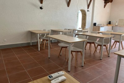 Porte-fenêtre vitrée blanche encadrée de pierre, avec une plante grimpante et une jardinière en pierre à droite.