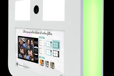 Borne photo interactive avec écran tactile affichant des options de filtres et de décors personnalisables.
