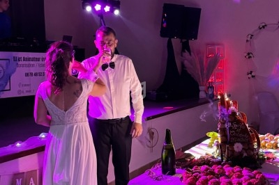 Un couple en tenue de mariage partage un moment devant une table garnie de desserts et de décorations festives.