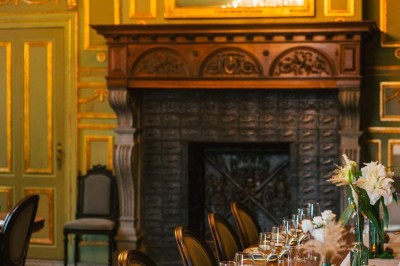 Bâtiment moderne en bois noir avec toit en pente, entouré d'arbres et d'un sol couvert de feuilles d'automne.