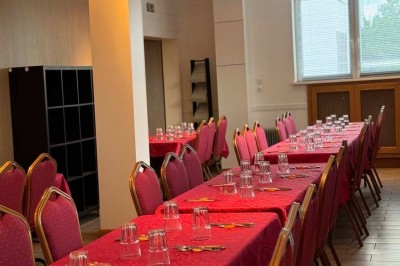 Boule de bowling jaune posée sur une piste en bois, avec des quilles alignées au fond et des lumières colorées.