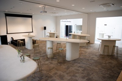 Miniature Grande salle - Format Soirée ( mobilier non fourni) Salle de réunion lumineuse avec une table blanche, des chaises grises, un écran mural et un tableau de présentation.