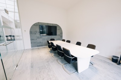 Miniature Salle de réunion - Compose Salle de réunion lumineuse avec une table blanche, des chaises grises, un écran mural et un tableau de présentation.