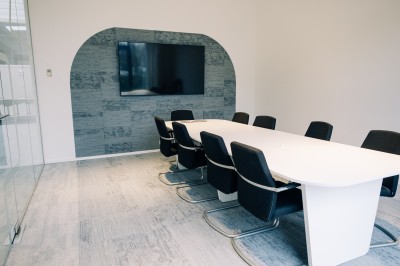 Miniature Salle de réunion - Compose Salle de réunion lumineuse avec une table blanche, des chaises grises, un écran mural et un tableau de présentation.
