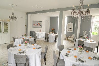 Groupe de personnes réunies dans une salle lumineuse autour d'un buffet varié avec boissons et plats.