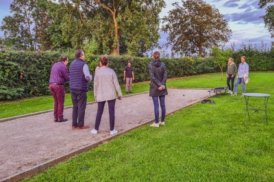 Groupe de personnes réunies dans une salle lumineuse autour d'un buffet varié avec boissons et plats.