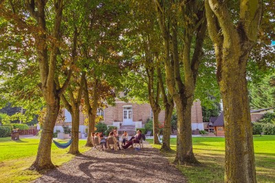 Groupe de personnes réunies dans une salle lumineuse autour d'un buffet varié avec boissons et plats.