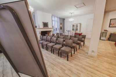 Groupe de personnes réunies dans une salle lumineuse autour d'un buffet varié avec boissons et plats.