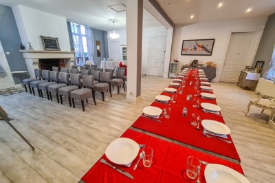 Groupe de personnes réunies dans une salle lumineuse autour d'un buffet varié avec boissons et plats.