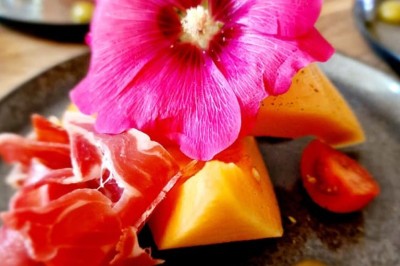 Groupe de personnes réunies dans une salle lumineuse autour d'un buffet varié avec boissons et plats.