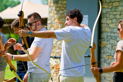 Voilier blanc amarré sur un lac calme, entouré de montagnes verdoyantes sous un ciel dégagé.