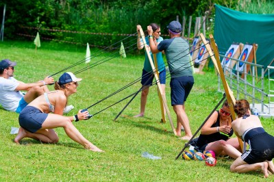 Voilier blanc amarré sur un lac calme, entouré de montagnes verdoyantes sous un ciel dégagé.