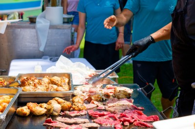 Voilier blanc amarré sur un lac calme, entouré de montagnes verdoyantes sous un ciel dégagé.