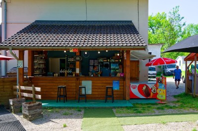 Voilier blanc amarré sur un lac calme, entouré de montagnes verdoyantes sous un ciel dégagé.