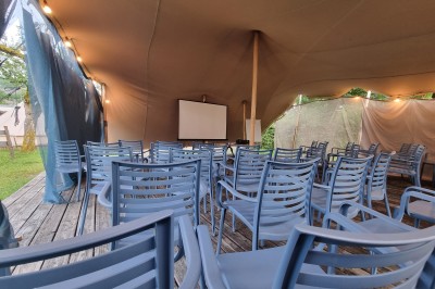 Voilier blanc amarré sur un lac calme, entouré de montagnes verdoyantes sous un ciel dégagé.