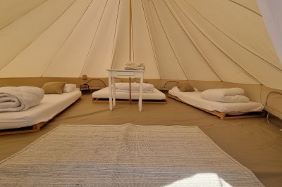 Voilier blanc amarré sur un lac calme, entouré de montagnes verdoyantes sous un ciel dégagé.