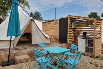 Voilier blanc amarré sur un lac calme, entouré de montagnes verdoyantes sous un ciel dégagé.