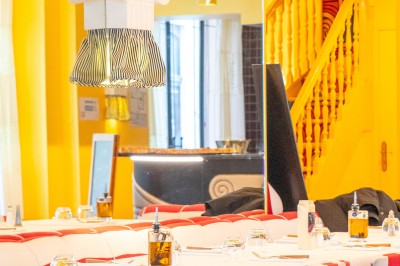 Miniature Location salle Lille (Nord) - Pizza Armand #5 Salle de restaurant lumineuse avec tables dressées, banquettes rayées rouges et blanches, et décor coloré.