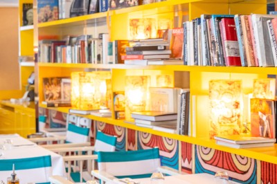 Miniature Location salle Lille (Nord) - Pizza Armand #4 Salle de restaurant lumineuse avec tables dressées, banquettes rayées rouges et blanches, et décor coloré.