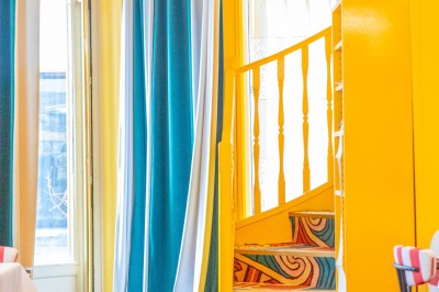 Miniature Location salle Lille (Nord) - Pizza Armand #6 Salle de restaurant lumineuse avec tables dressées, banquettes rayées rouges et blanches, et décor coloré.