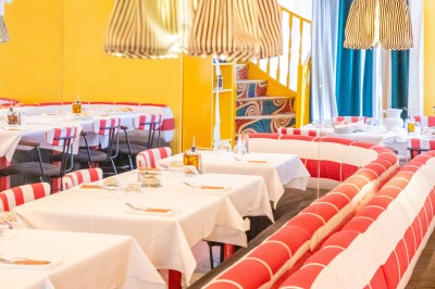 Miniature Location salle Lille (Nord) - Pizza Armand #2 Salle de restaurant lumineuse avec tables dressées, banquettes rayées rouges et blanches, et décor coloré.