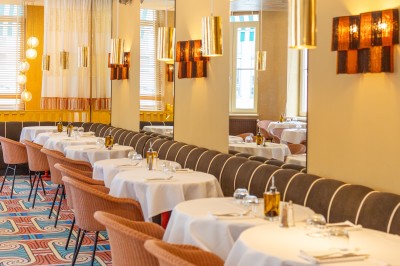 Miniature Location salle Lille (Nord) - Pizza Armand #3 Salle de restaurant lumineuse avec tables dressées, banquettes rayées rouges et blanches, et décor coloré.