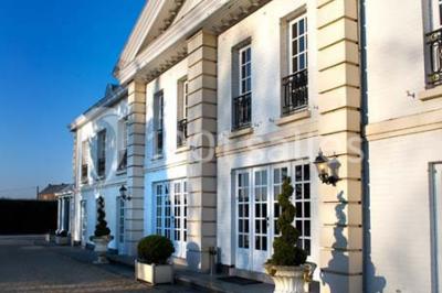 Lustre en cristal allumé suspendu au-dessus d'un escalier avec rampe en fer forgé et sol en marbre.