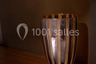 Lustre en cristal allumé suspendu au-dessus d'un escalier avec rampe en fer forgé et sol en marbre.