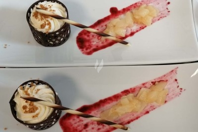 Plateau de fromages variés entourés de grappes de raisin, noix et herbes fraîches sur une table claire.