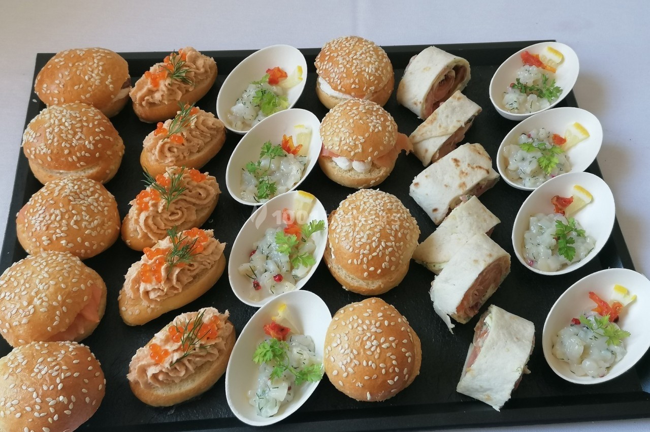 Plateau de bouchées apéritives variées comprenant mini-burgers, wraps, verrines et toasts garnis.