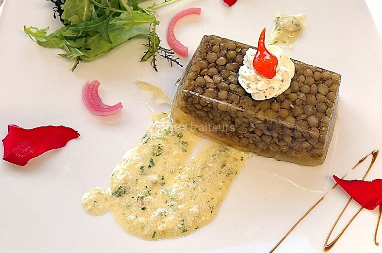 Assiette gastronomique avec un cube de lentilles en gelée, sauce crémeuse, salade verte et décorations colorées.