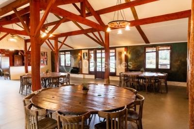 Tente beige en toile installée dans une clairière entourée d'arbres.