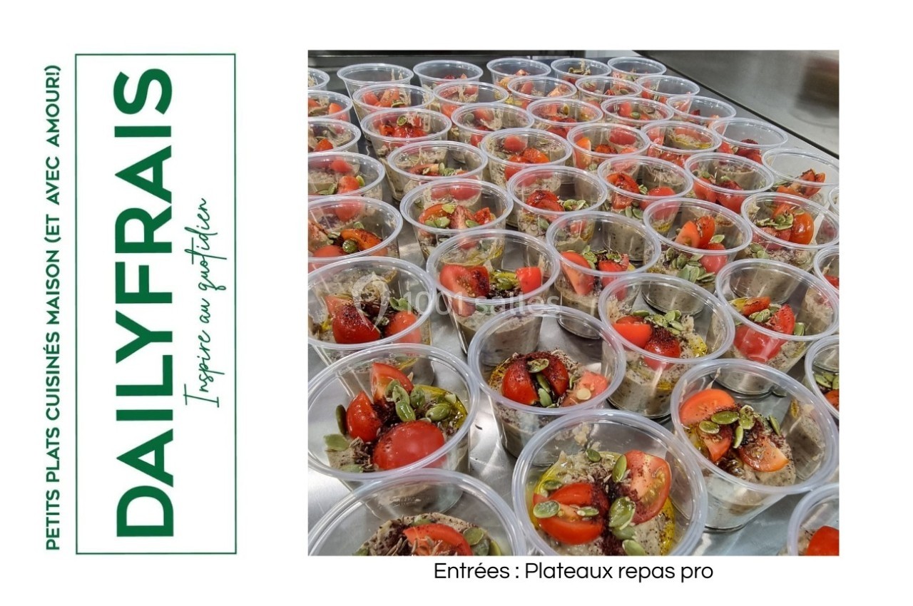 Des salades individuelles colorées avec tomates cerises, olives et herbes, présentées dans des pots transparents.